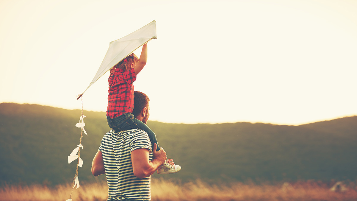 happy family father and child on meadow with a kite in the summer on the nature